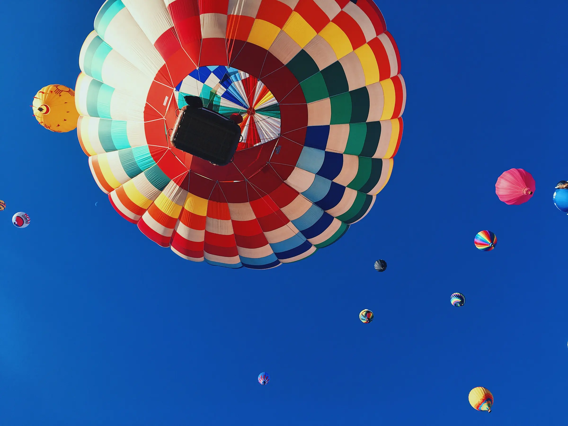 Colorful hot-air balloons floating across a brilliant blue sky