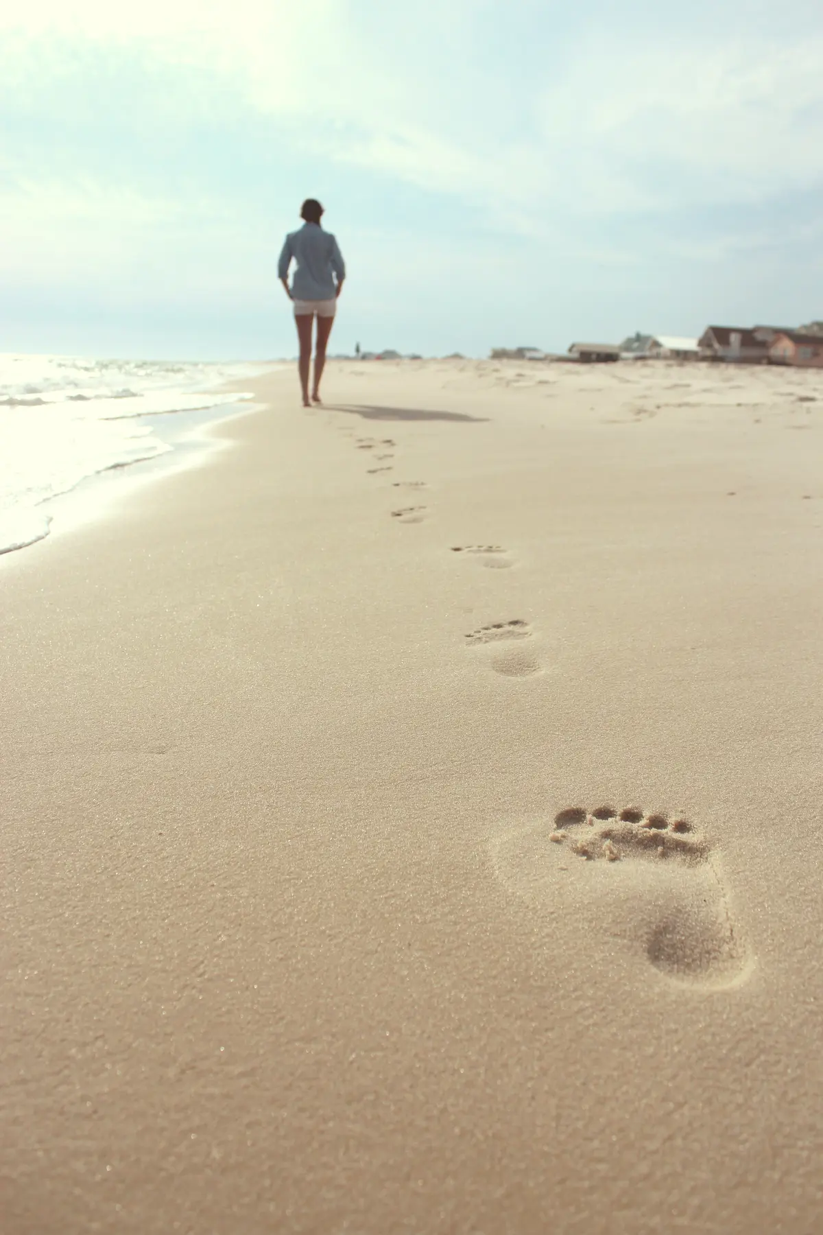 Footprints leading along a quiet beach