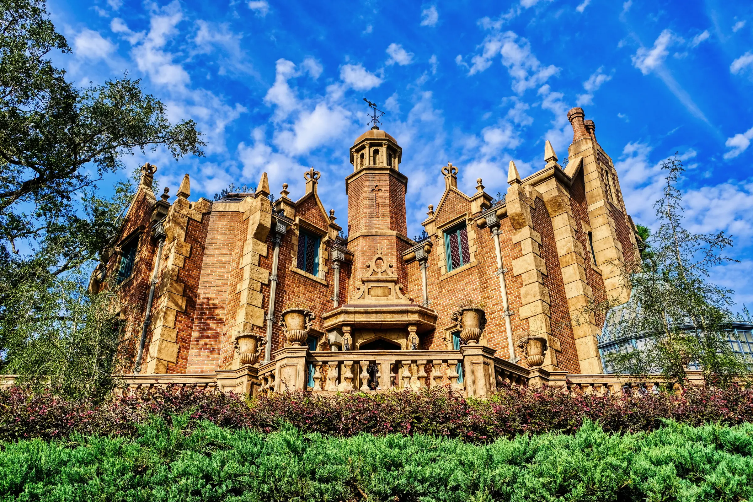 The Haunted Mansion at Magic Kingdom beneath a vivid blue sky